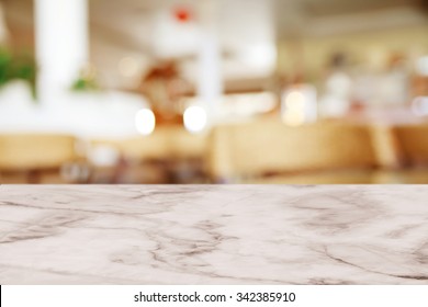 Empty White Marble Table With Blur Cafe Background.