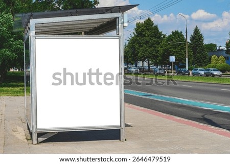 An empty white mock-up of a vertical light box at a bus stop