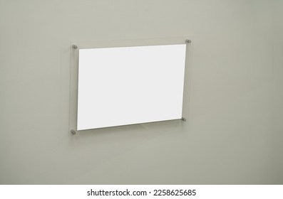 Empty white paper sheet in glass frame fixed on concrete wall. Information and advertising message. - Shutterstock ID 2258625685