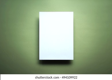 Empty white paper sheet isolated on green background
