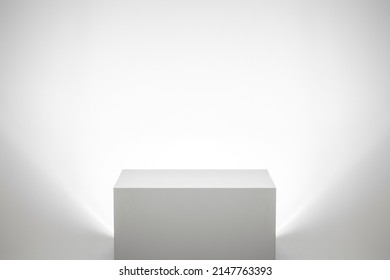 Empty white pedestal backlit in bright white studio landscape interior