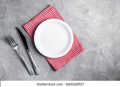 Empty white plate with nupkin on a gray stone background - Powered by Shutterstock