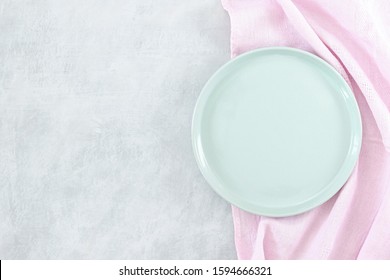 Empty White Plate On Grey Stone Table And Napkin. Food Background For Menu, Recipe. Table Setting. Flatlay, Top View. Mockup For Restaurant Dish