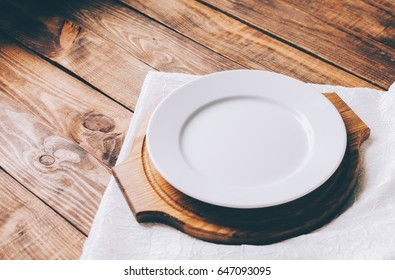 Empty white plate on home wooden table