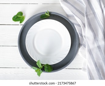 Empty White Plate On A Table, Dinner Setting, Mockup For Food Styling. Tablecloth And Cement Round Tray. Top View