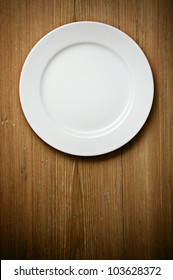 Empty White Plate On Wooden Table