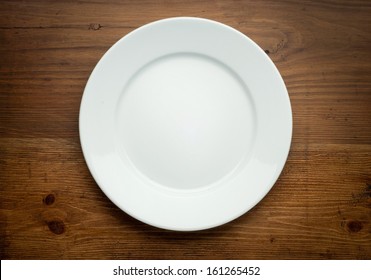 Empty White Plate On Wooden Table