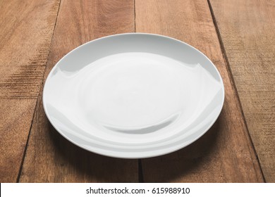 Empty White Plate On Wooden Table