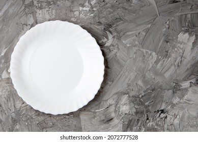 Empty White Plate Over Gray Concrete Background. Top View