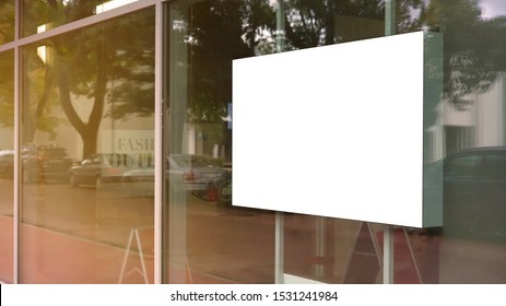 empty white poster frame on glass of showcase window of shopping mall fashion outlet centre mock-up