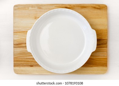 Empty White Round Baking Pan On The Wooden Tray Staying On The White Wooden Table