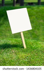 Empty White Sign Board On A Small Hill With Freshly Cut Green Grass And Meadow In The Background