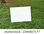 Empty white sign suitable for mock up in a yard of grass lawn. 