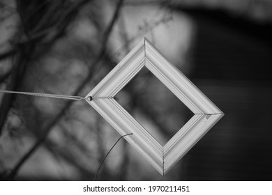 an empty white square frame is attached to the cord outdoor installation