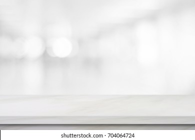 Empty white table top, counter, desk background over blur perspective bokeh light background, White marble stone table, shelf and blurred kitchen restaurant for food, product display mockup, template