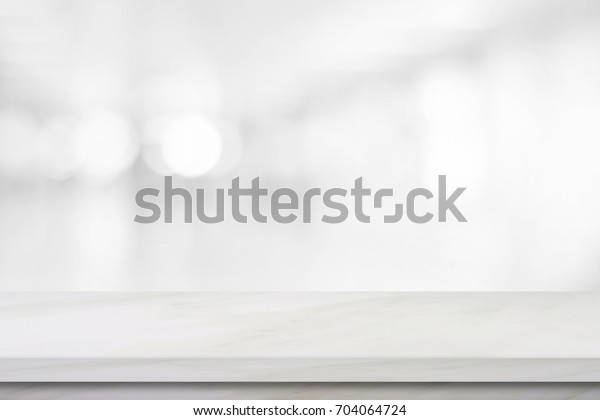Empty white table top, counter, desk background\
over blur perspective bokeh light background, White marble stone\
table, shelf and blurred kitchen restaurant for food, product\
display mockup, template