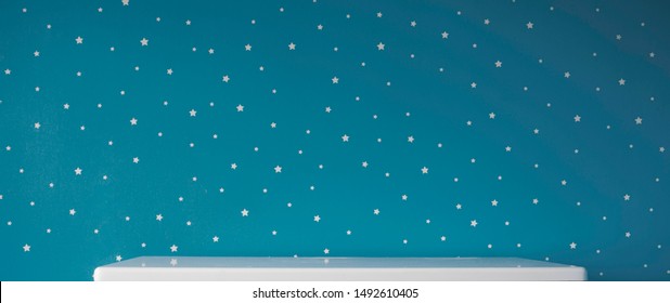 Empty White Table Top On Dark Blue Starry Wall In Kids Bedroom