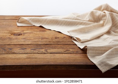 Empty white tablecloth on wooden desk perspective. Selective focus.