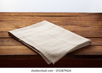 Empty white tablecloth on wooden desk perspective. Selective focus.