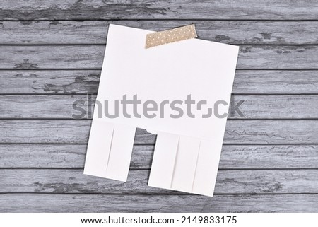 Empty white tear-off stub paper note without text on wooden wall
