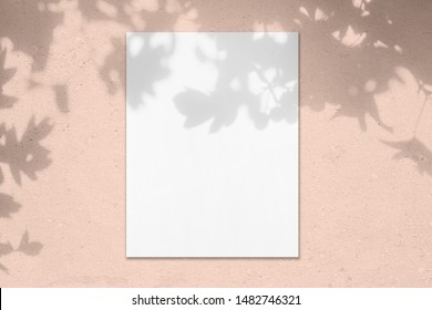 Empty White Vertical Rectangle Poster Mockup With Soft Shadow On Pastel Pink Colored Concrete Wall Background. Flat Lay, Top View