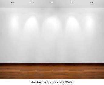 Empty white wall with 5 spot lights and wooden floor