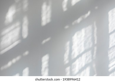 Empty white wall with sunlight shining through a window - concept of sunbeams to overlay a photo