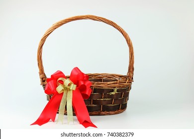 Empty Wicker With Red-gold Ribbon Flower Bow Decorating On White Copy Space Background For Christmas And New Year Gift Basket Event