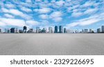 Empty wide asphalt road and city skyline. Side asphalt tarmac floor with buildings and modern cityscape, white clouds and blue sky background, highway for transportation, cloudy sky, high angle view
