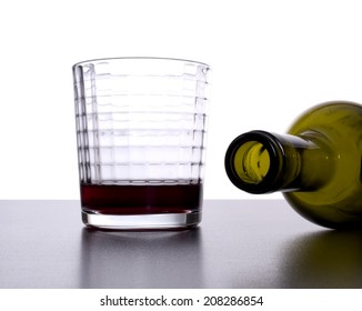 Empty Wine Bottle Tipped Over Next To Nearly Empty Glass