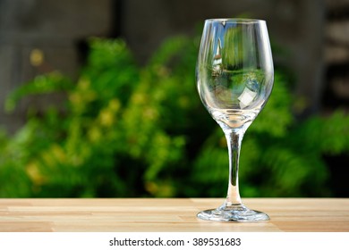 Empty Wine Glass On Table In Green Park Background