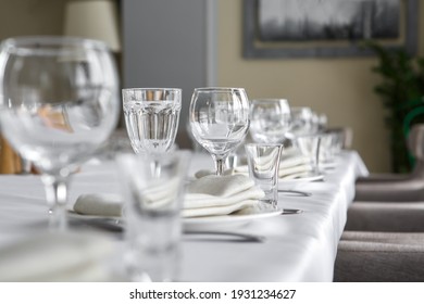 Empty wine glasses are on the table in the restaurant. Fragment of table setting