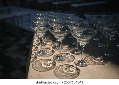 Empty wine glasses on a table in backyard. Table with empty wine glasses at a summer wedding. Festive wedding concept. Side view.