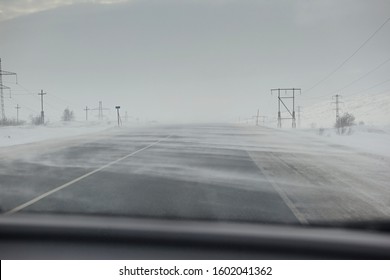 Empty Winter Snowy Road Without Cars, It Is Snowing And A Strong Wind. Bad Weather And Harsh Conditions Of The North