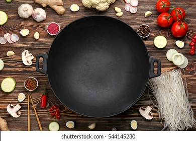 Empty Wok Pan With Fresh Ingredients On Wooden Background, Top View