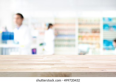 Empty wood counter top on blur pharmacy (chemist or drugstore) background
