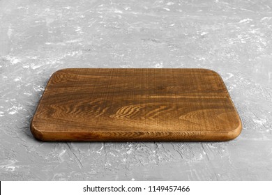 Empty Wood Cutting Board On Gray Background With Copy Space. Perspective View.