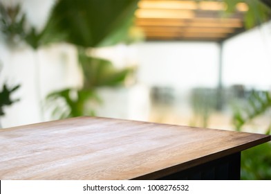 Empty Wood Desk Over Blurred Montage Coffee Shop Cafe / Restaurant Background