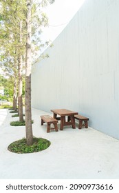 Empty Wood Outdoor Patio Table And Chair Set With White Wall