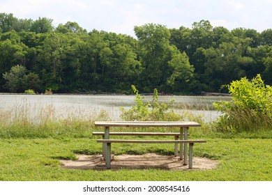 The Empty Wood Picnic Table On The Riverbank At The River.