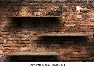 Empty Wood Shelf On Old Brick Wall Background, Grunge Industrial Interior Uneven Diffuse Lighting Version.