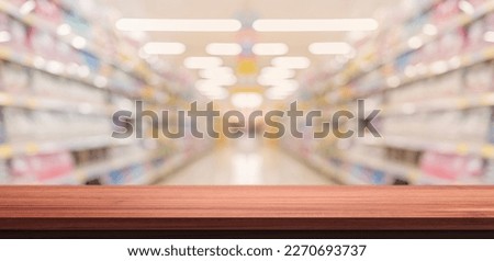 empty wood table in blurry background with shelves in supermarket