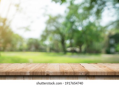 Empty wood table and defocused bokeh and blur background of garden trees with sunlight. product display template. - Shutterstock ID 1917654740