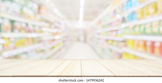 Empty wood table top with abstract supermarket grocery store aisle blurred defocused background with bokeh light for product display