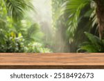 Empty wood table top with blur background of tropical jungle in summer green. The table giving copy space for placing advertising product on the table along with beautiful forest banner background.