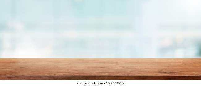 Empty wood table top and blur glass window wall building banner mock up abstract background - can used for display or montage your products.