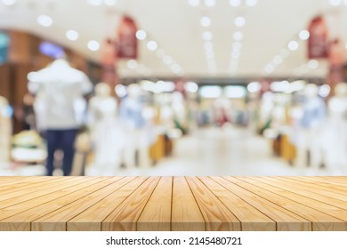 Empty Wood Table Top With Blur Clothing Boutique Display Interior Shopping Mall Background