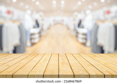 Empty Wood Table Top With Blur Clothing Boutique Display Interior Shopping Mall Background