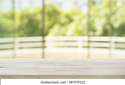 Empty wood table top with blur abstract green garden window view. For montage product display 