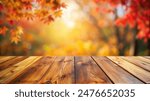 Empty wood table top and blurred autumn tree and red leaf background - can used for display or montage your products